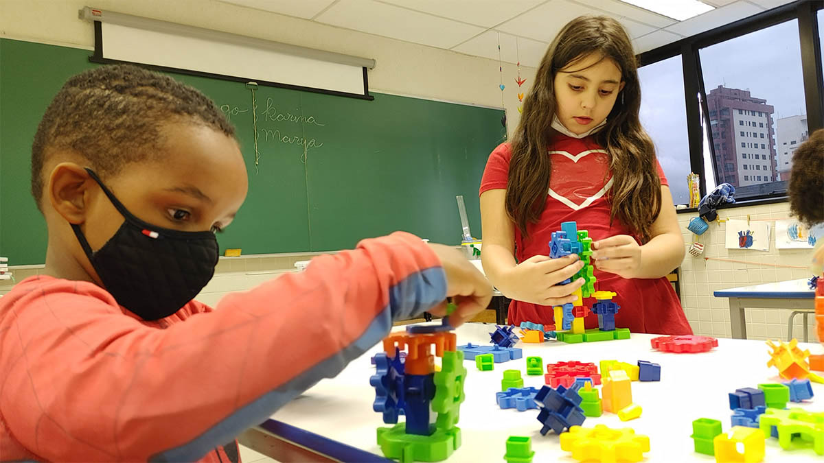 Imagem de alunos em sala em atividades diversas, montando objetos com peças coloridas