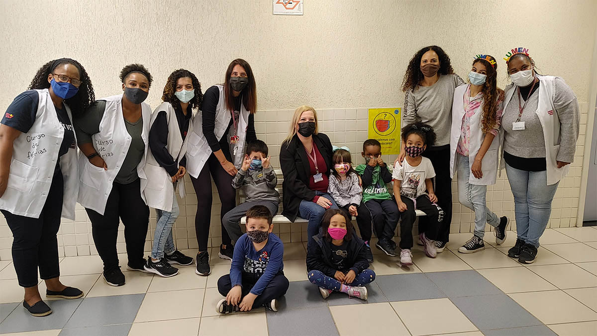 Imagem de alunos e equipe pedagógica posando para foto