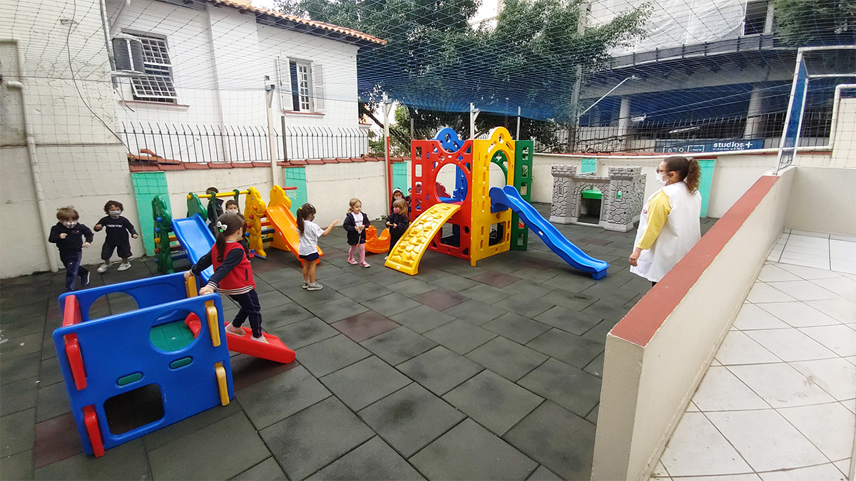 Foto de alunos em brinquedos no playground